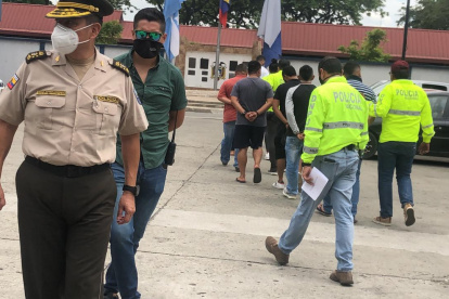 Al fondo las siete personas que fueron detenidas tras asaltar a comerciantes asiáticos.
