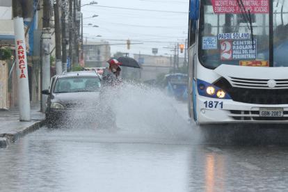 Sur. Dos ciudadanos empapados por el agua que levantó un bus.