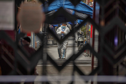 Un trabajador sanitario recorre la urbanización Guixi, que se encuentra confinada tras registrase varios casos de la covid-19, en Shanghái (China) este martes.