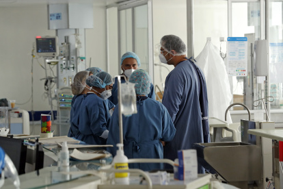 Personal médico atiende a un enfermo en una unidad de cuidado intensivo de COVID.