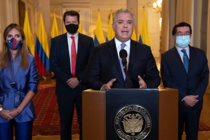 Iván Duque (2d), acompañado por el ministro de Salud, Fernando Ruiz (d), mientras anuncia la llegada del primer cargamento de vacunas.