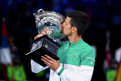 Novak Djokovic besa el trofeo luego de hacer suyo por novena ocasión el Abierto de Australia.