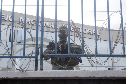 Un elemento militar custodio el Consejo Nacional Electoral detrás de una vallado en el perímetro de la institución.