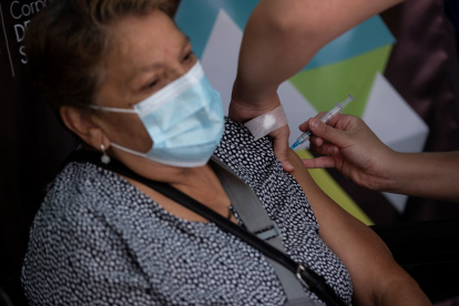 Una enfermera administra una dosis de la vacuna china del laboratorio Sinovac contra la covid-19 a una mujer, hoy en un centro de vacunación en Santiago (Chile).
