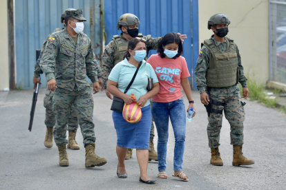 Familiares de los reclusos esperan ayer información sobre sus seres queridos frente al Centro de Privación de Libertad Zonal 8, una de las cuatro cárceles ecuatorianas donde este martes se produjeron motines, en Guayaquil.