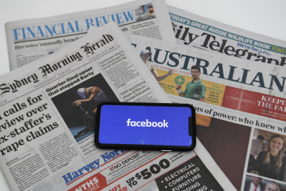 An illustration image shows a phone screen with the Facebook logo and Australian Newspapers at Parliament House in Canberra, Australia. EFE/EPA/LUKAS COCH