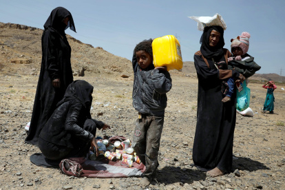 Yemeníes desplazados llevan sus raciones de alimentos proporcionadas por Mona Relief Yemen antes de una conferencia internacional de donantes sobre Yemen.