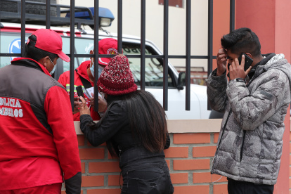 Un bombero habla con una mujer que espera información tras el accidente en el que murieron varios estudiantes hoy, en El Alto (Bolivia).