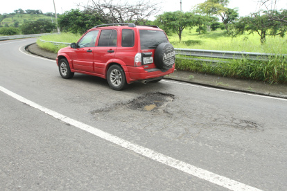 Tratar de evadir un bache en una curva es un riesgo, puede ocurrir un accidente de tránsito.