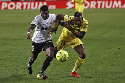 Pervis Estupiñán (d), lateral ecuatoriano del Villarreal, intenta arrebatarle el balón a un rival.