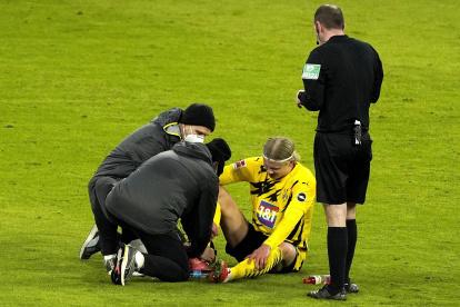 Erling Haaland, delantero del Borussia Dortmund, es atendido por los médicos de su club.