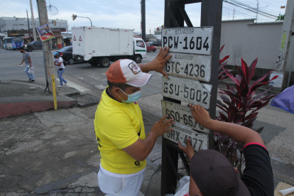 VENDEDORES AMBULANTES ENCONTRARON PLACAS DE LOS CARROS CAIDOS EN LA AVENIDAS Y BUSCARON LUGARES VISIBLES PARA QUE PUEDAN RECONOCER LAS PLAS POR EL FUERTE AGUACERO QUE SOPORTO GUAYAQUIL 9 DE MARZO DEL 2021 GUAYAQUIL-ECUADOR