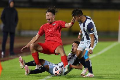 Andrés López (d), de Universidad Católica, disputa un balón con Carlos Ferreira, de Libertad.