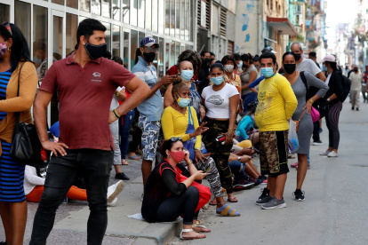 Grupos de personas con tapabocas hacen fila para comprar en un mercado, el 11 de marzo de 2021, en La Habana (Cuba).