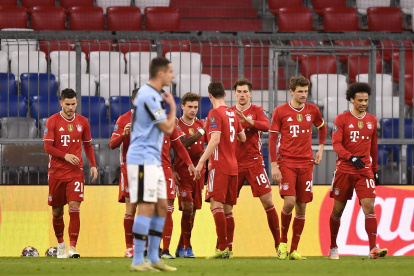 Los jugadores del Bayern Múnich celebran ante el lamento de un jugador del Lazio.