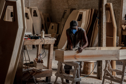 -FOTOGALERIA- / ACOMPAÑA CRÓNICA: BRASIL FUNERARIAS - AME3589. FEIRA DE SANTANA (BRASIL), 18/03/2021.- Un hombre trabaja en la fabricación de ataúdes el 15 de marzo de 2021, en Feira de Santana (Brasil). La fuerte alza del dólar, con picos máximos en los últimos días, ha puesto en jaque a la industria funeraria en Brasil. Su escalada ha impulsado las exportaciones y desviado al exterior la madera para producir ataúdes en momentos en los que el país vive la peor fase de la pandemia. La Asociación de los Fabricantes de Urnas de Brasil (AFUB) en un comunicado enviado al mercado funerario alertó que, "de forma general, habrá nuevamente restricción de modelos de urnas (como los utilizados para personas obesas) y el abastecimiento es incierto". EFE/ Felipe Iruatã
