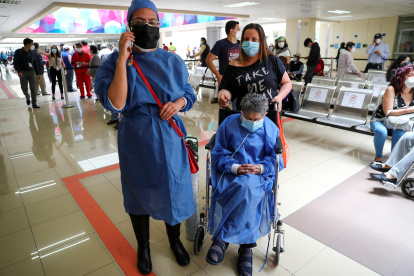 Una adulta mayor espera el 25 de marzo de 2021 para ser vacunada contra la covid-19, acompañada por una familiar en el Hospital Luz Elena Arismendi de Quito (Ecuador).