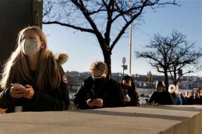 Personas esperan en la fila para recibir las vacunas contra la covid-19 en un sitio de vacunación.