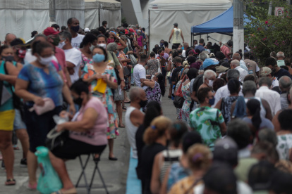Grupos de personas hacen fila para recibir la vacuna contra la Covid-19 hoy, en la ciudad de Duque de Caxias (Brasil).
