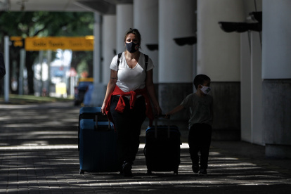 AME6722. BUENOS AIRES (ARGENTINA), 30/03/2021.- Grupos de personas caminan hoy, por el aeropuerto de Buenos Aires (Argentina). Argentina cierra por completo sus fronteras terrestres y restringe vuelos internacionales para frenar la llegada de las variantes de la covid-19 y enfrentar la nueva escalada de contagios, considerada ya como segunda ola, que coincide con el comienzo del otoño y el lento avance del plan de vacunación. EFE/ Juan Ignacio Roncoroni