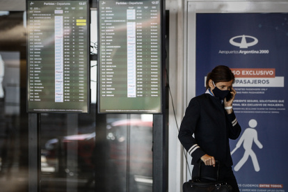 Grupos de personas caminan hoy, por el aeropuerto de Buenos Aires (Argentina).