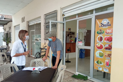 Visita. Funcionaria municipal habla con el administrador de un local.