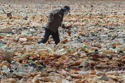Un funcionario de la Unidad de Salud del Gobierno Municipal, camina entre la contaminación del lago Uru Uru el 30 de marzo de 2021 en Oruro (Bolivia).