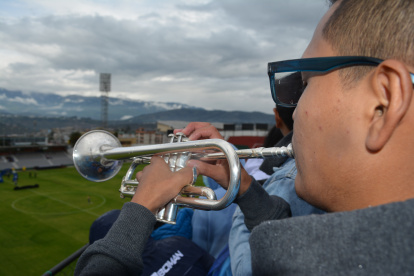 Un aficionado toca la trompeta desde una de las terrazas donde se ven los partidos que se juegan en el estadio Bellavista.