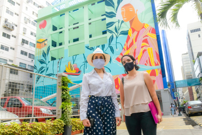 La gerente de la Empresa Pública de Turismo, Gloria Gallardo (i), frente a un mural de la calle Panamá.