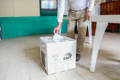 Un votante deposita la papeleta luego de firmar el registro. Loja vota en calma