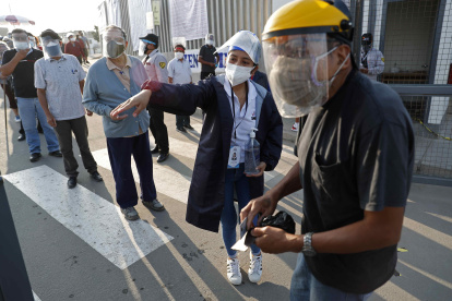 Un hombre recibe instrucciones para encontrar su puesto de votación hoy, en un colegio electoral del distrito de Villa El Salvador, en Lima.