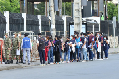Personal de la mesa del recinto electoral haciendo fila para ingresar a una institución.