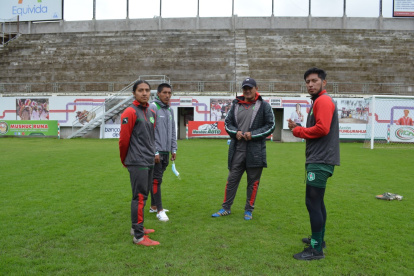 Athy Lozano (i), Jonathan Capuz y Bryan Caisabanda (d), jugadores indígenas de Mushuc Runa, mientras conversan con Geovanny Cumbicus, entrenador de Ponchito.