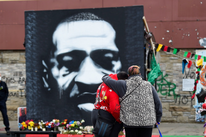 Una pareja frente a un retrato de George Floyd este 20 de abril de 2021 en Minéapolis.