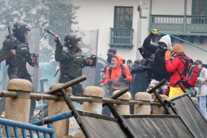 Manifestantes se enfrentan con agentes de Policía durante una protesta el 28 de abril de 2021, en la Plaza de Bolívar de Bogotá.