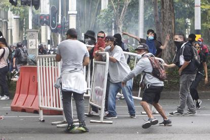 Manifestantes se enfrentan a las autoridades en las protestas contra la reforma tributaria convocadas por las centrales obreras, hoy en Medellín (Colombia). Miles de colombianos salieron hoy a las calles del país con arengas, bailes y música para rechazar el proyecto de reforma fiscal presentado por el Gobierno del presidente Iván Duque, en una jornada multitudinaria que avanza de manera pacífica, con excepción de Cali, Bogotá y Medellín donde han ocurrido desórdenes y saqueos. EFE/Luis Eduardo Noriega A. Protestas en la ciudad colombiana de Medellín contra la reforma tributaria