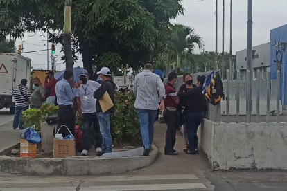 Familiares de la víctima permanecen fuera de la morgue a la espera de que les entreguen su cuerpo.