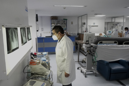 El doctor Juan Carlos Aveiga, director médico del hospital Alcívar de Guayaquil, revisa la historia médica de un paciente dentro de la unidad de cuidados intensivos no COVID.