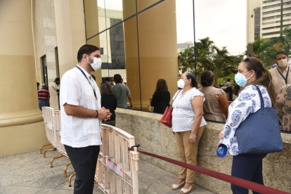El coordinador Zonal 8 del Registro Civil, Andrés Fantoni Baldeón, habla con usuarios que hacen fila para sacar el pasaporte en Guayaquil.