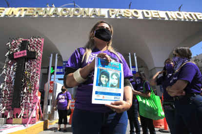 Perla Reyes, madre de Jocelyn Calderón Reyes, muestra hoy un cartel con una imagen de su hija, durante una protesta para exigir el esclarecimiento del caso tras 9 años de su desaparición en Ciudad Juárez.