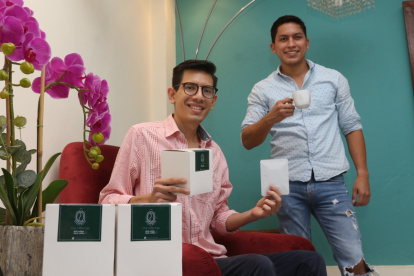 Josué y Pepe posan y muestran su emprendimiento de café para filtrar.