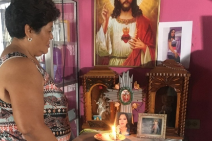 Nube Dolores mantiene todo el día una vela encendida por su hija Johanna Tapia. Su foto está en medio de varias imágenes de santos.