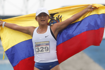 Glenda Morejón, marchista ecuatoriana,  muestra la bandera nacional tras lograr la medalla de oro.