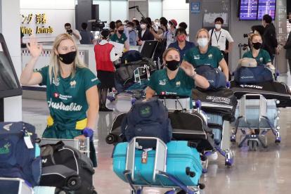 Las seleccionadas del equipo australiano de sóftbol arribando al aeropuerto tokiota de Narita.