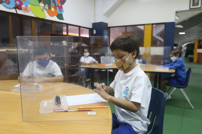 Desde sus pupitres a dos metros de distancia y separados por mamparas, los alumnos del Balandra Cruz del Sur cruzan miradas entre ellos.