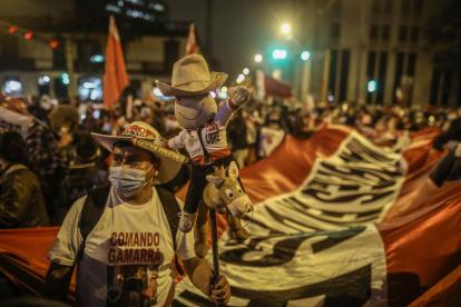 Simpatizantes de Pedro Castillo esperan los resultados electorales hoy, frente a su local central de campaña en Lima (Perú).