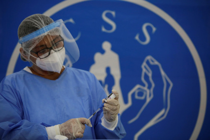 Personal médico de la Caja del Seguro Social de Panamá (CSS), prepara una primera dosis de AstraZeneca.