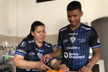 Pedro Vite, junto a su madre Luz María Uca, mientras le enseña a cocinar.