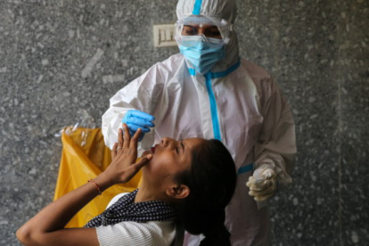 Un médico recoge muestras de las fosas nasale de una ciudadana en Nueva Delhi.