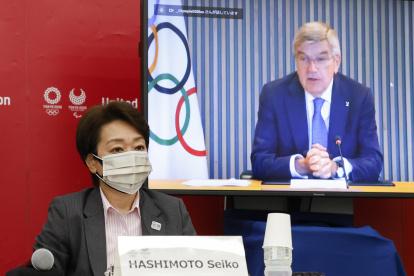 La presidenta del comité organizador de los JJ.OO. Tokio 2020, Seiko Hashimoto (izquierda) y el presidente del COI, Thomas Bach (en pantalla).